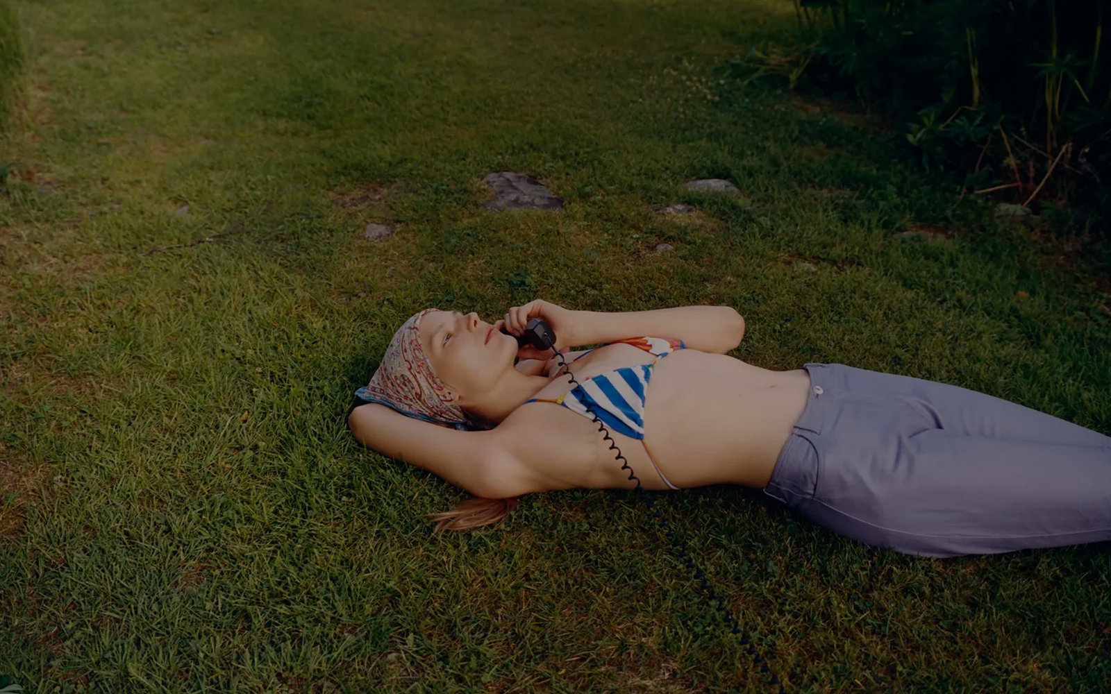 Person lying on grass holding a phone